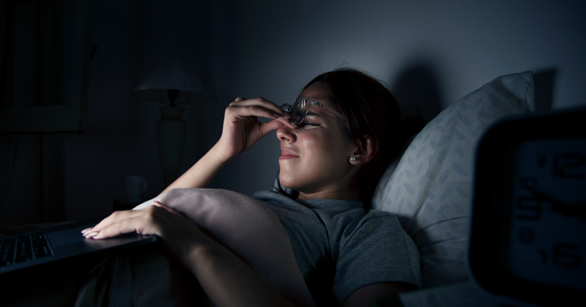 Woman rubbing eyes at night